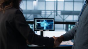 Apretón de manos con una computadora de fondo mostrando un software de inteligencia logística